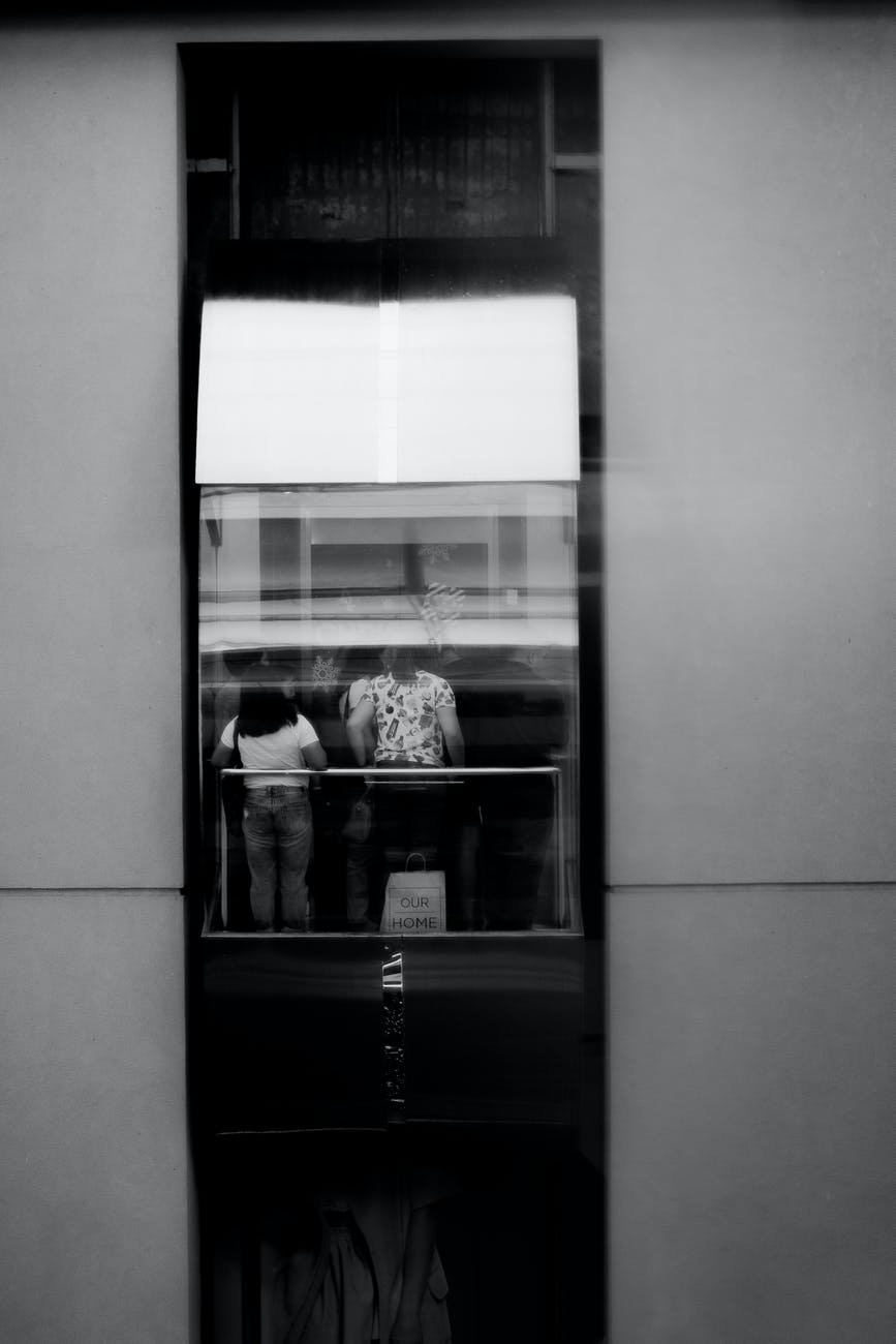grayscale photography of people inside elevator